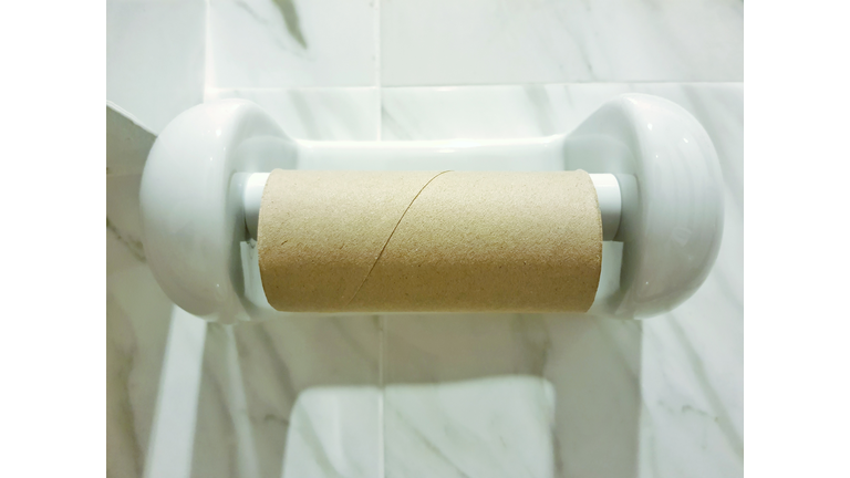 Close-Up Of Toilet Roll Holder On Wall In Bathroom