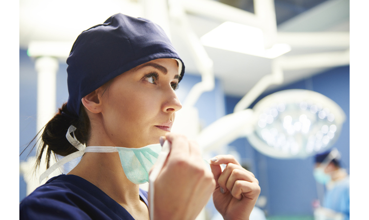 Female Doctor Wearing Surgical Mask While Standing In Operating Room