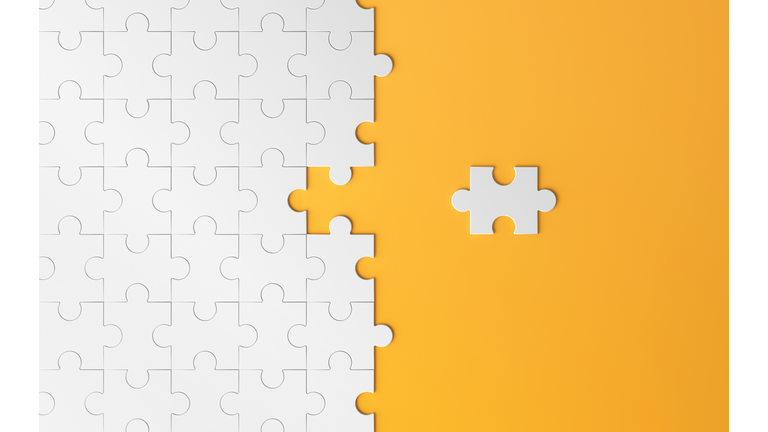 High Angle View Of Jigsaw Piece And Puzzle Against Yellow Background