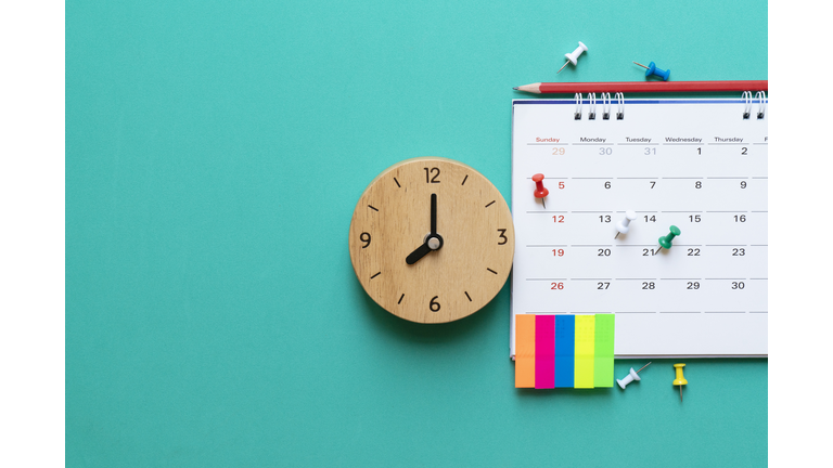 close up of calendar and clock on green background, planning for business meeting or travel planning concept