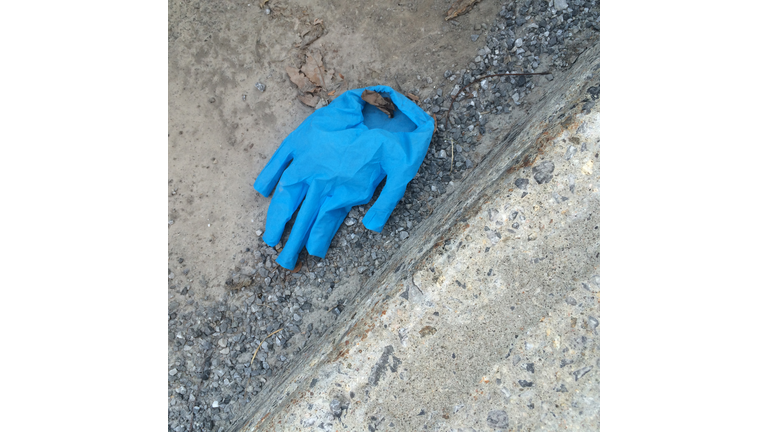 Disposable Protective Blue Glove on the Ground