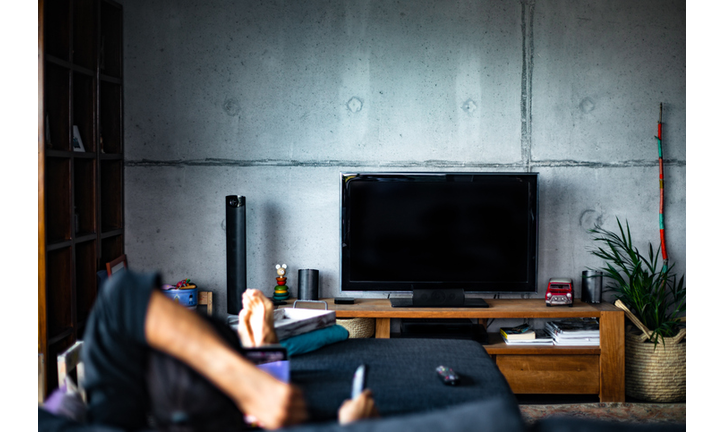 Rear view of a man watching television in a living room