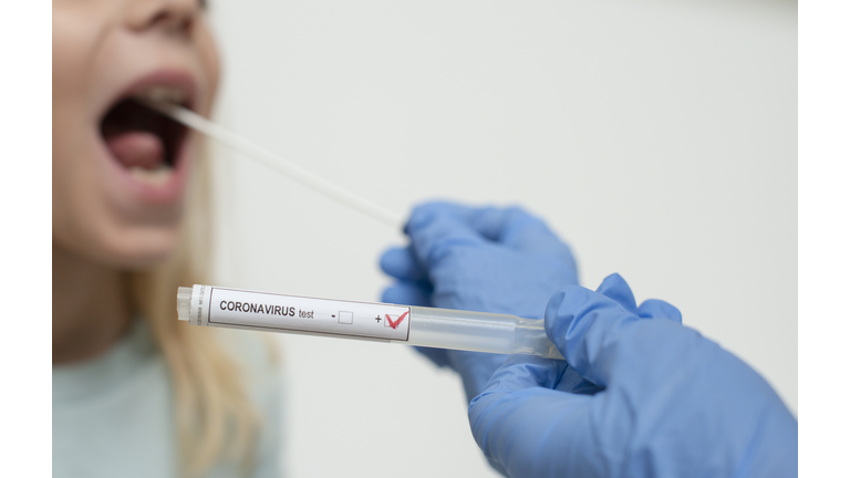 Close up of nurses hands holding buccal cotton swab and test tube ready to collect Coronarovirus test, COVID-19, 2019-nCOV analysis