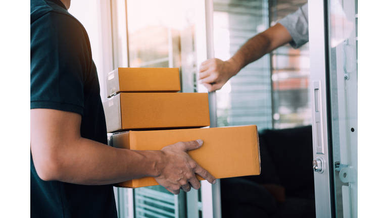 Midsection Of Man Delivering Packages To Male Customer At House