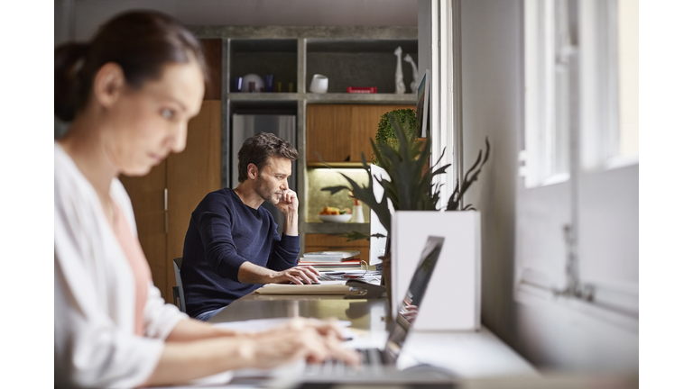 Mid-adult business couple working from home.