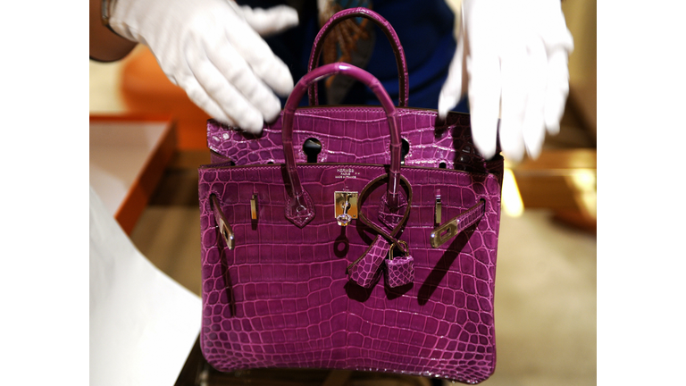 A woman inspects Hermes crocodile skin b