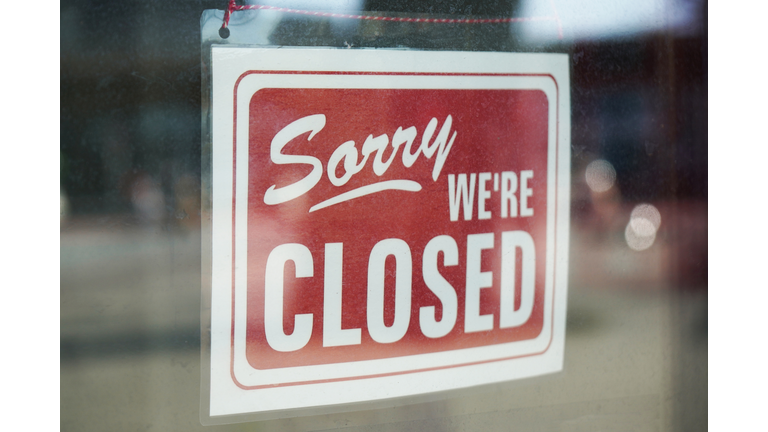 Sorry We're Closed Sign Behind Dirty Glass Door During Corona Lockdown