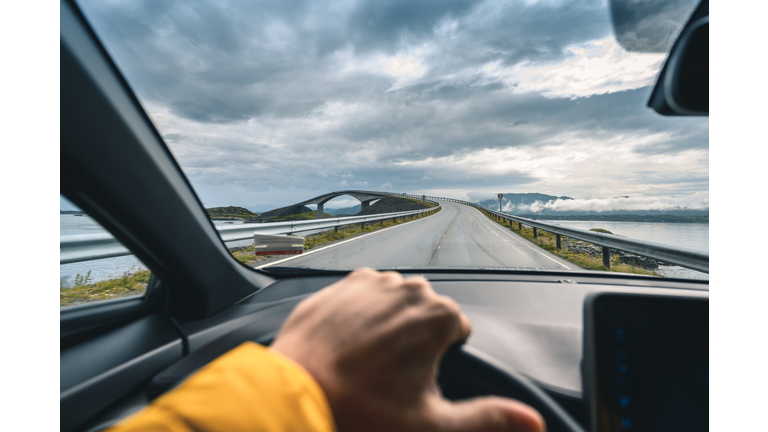 Personal perspective of man driving along the Atlantic Ocean Road, Norway