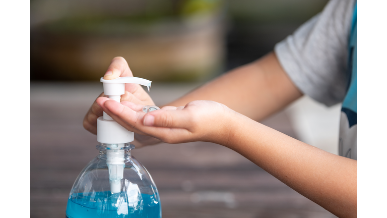 Child Hands Using Wash Hand Sanitizer Gel.