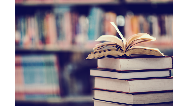 Books On Table Against Shelf In Library