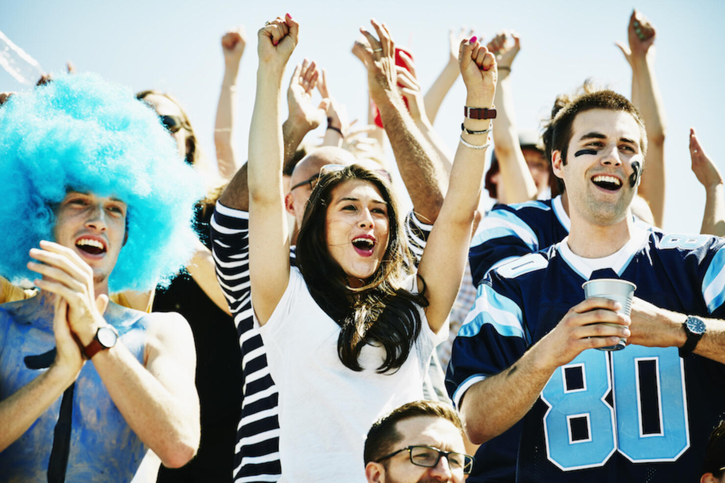 Football fans in stadium celebrating touchdown