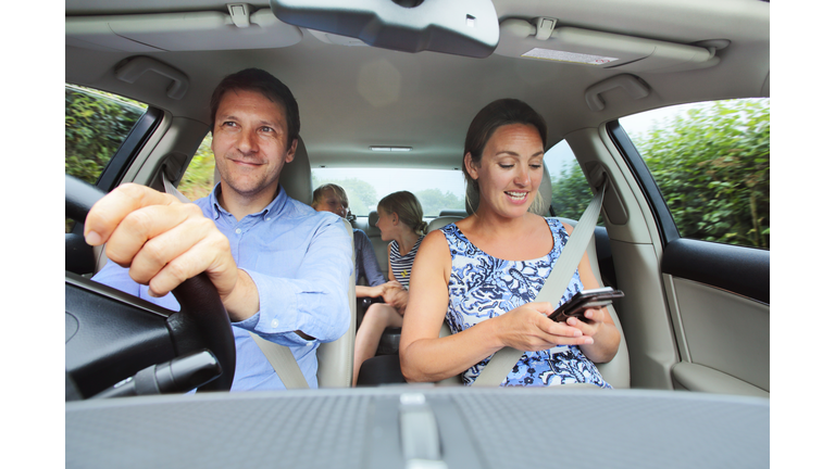 Family in car, mum looking at phone