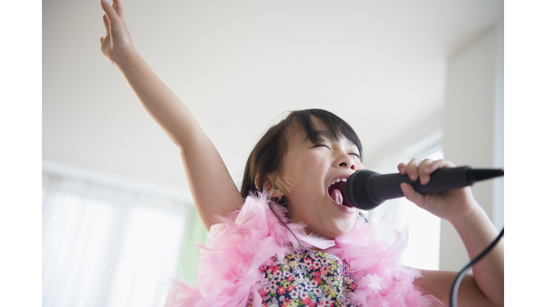 Filipino girl singing karaoke in living room