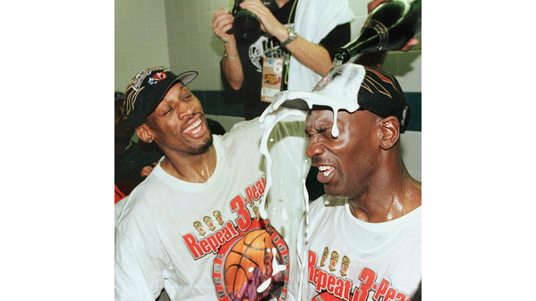 Dennis Rodman (L) of the Chicago Bulls pours champ