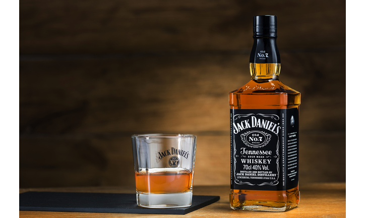 Jack Daniel's with glass on wooden background