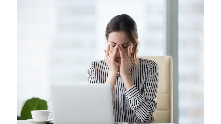 Tired businesswoman massaging eyes feeling strain fatigue headache relieving pain