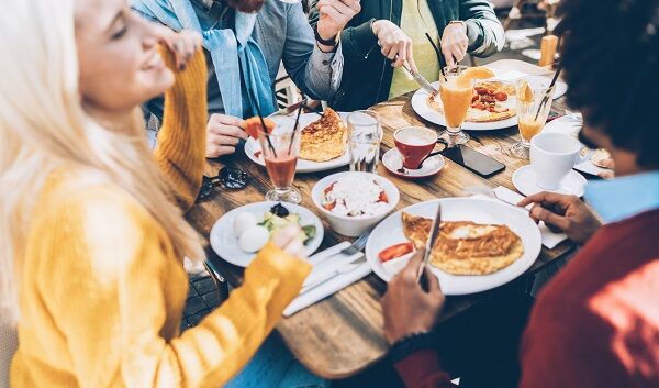 Multi ethnic group of friends eating lunch in a restaurant