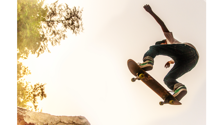 Teenage Boy Performing Stunt on Skateboard