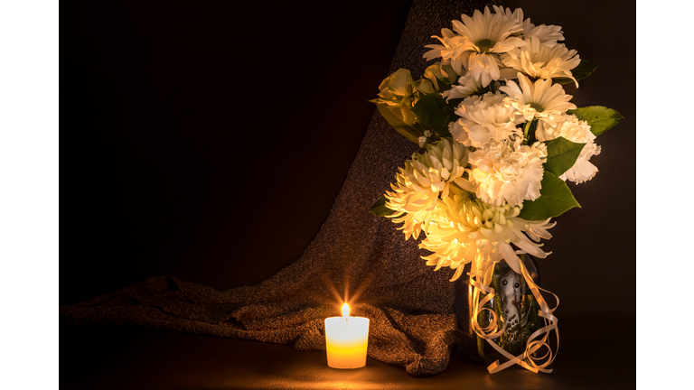 Beautiful Bouquet With White Flowers And Candle On Table Against Black Background