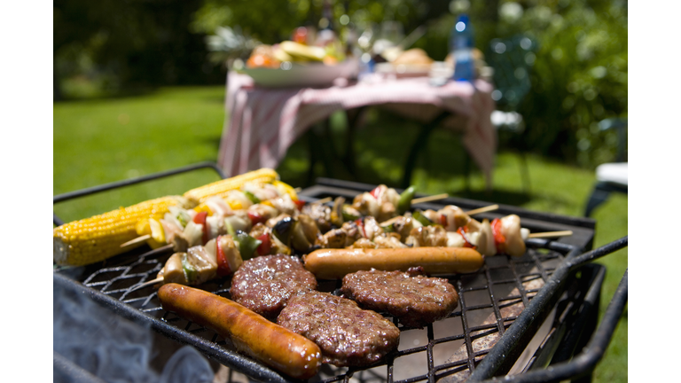 Food on barbecue by table in garden