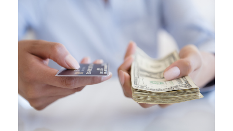 Hispanic woman holding cash and credit card