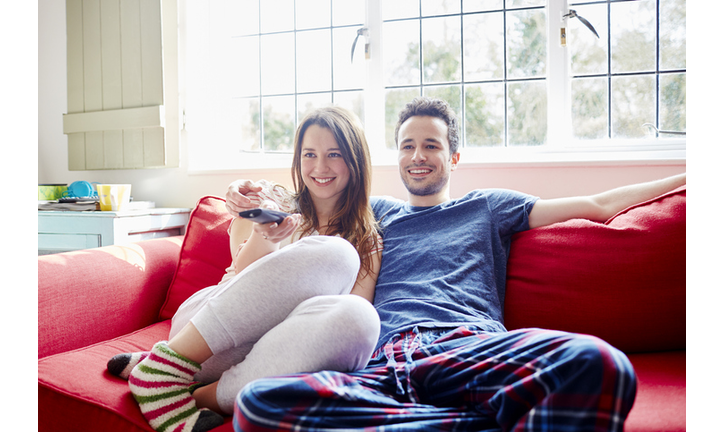 Young couple relax on sofa watching tv