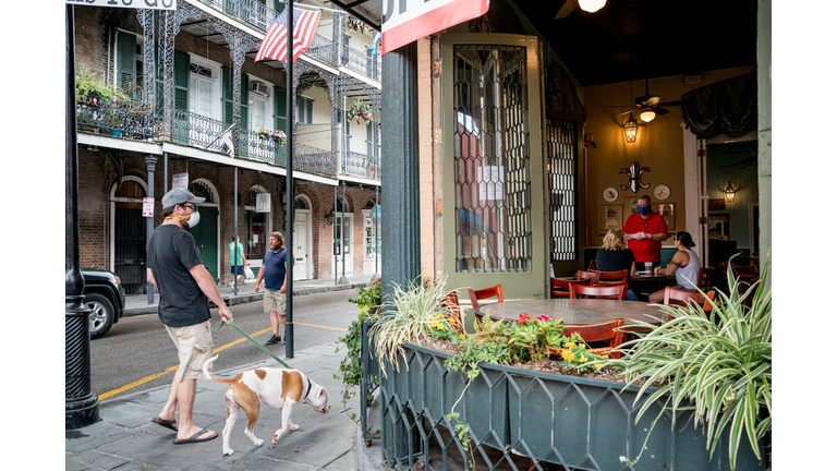 A man wearing a facemask walks past Pere Antoine's Restaurant in the French Quarter, open to patrons on the first day of New Orleans' reopening Phase 1, after two months of closures due to the novel coronavirus pandemic, in New Orleans, on May 16, 2020.  (Claire Bangser/AFP via Getty Images)