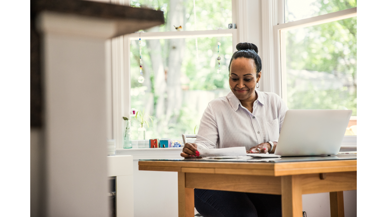 Woman working on laptop in kitchen