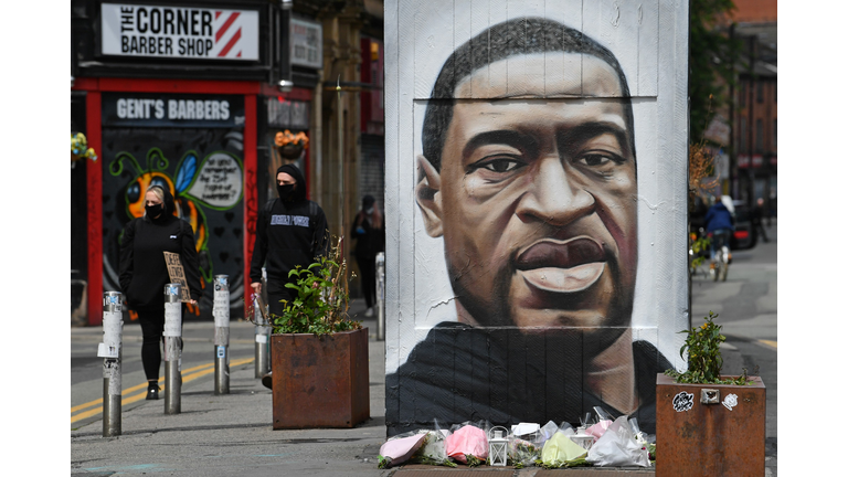 Flowers are seen beneath a mural of George Floyd, by street artist Akse, ahead of a demonstration in Manchester, northern England, on June 6, 2020, to show solidarity with the Black Lives Matter movement in the wake of the killing of George Floyd, an unarmed black man who died after a police officer knelt on his neck in Minneapolis, US. (Photo by Paul Ellis/AFP via Getty Images)