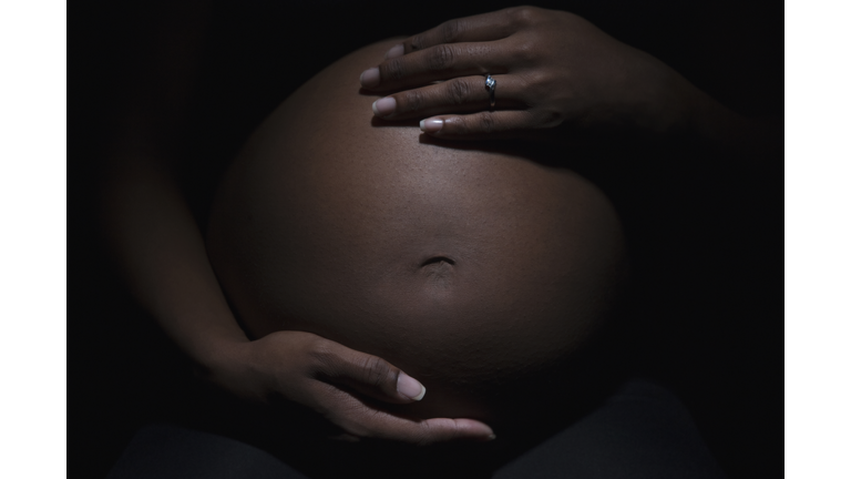 Close up of mixed race woman's pregnant stomach