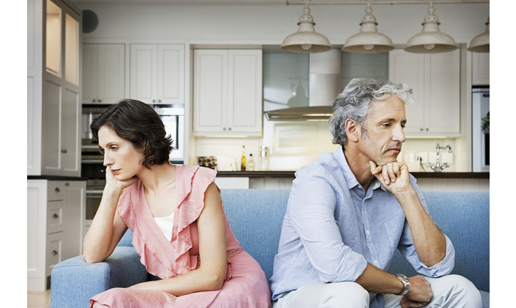 Sad couple sitting back to back