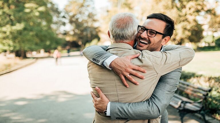 Family reunion. Father and son hugging outdoors.