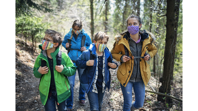 Family enjoying hiking in forest during the COVID-19 pandemic
