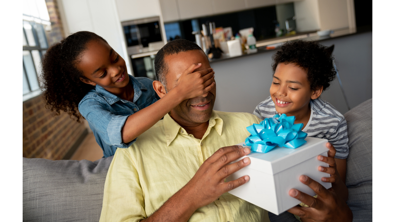 Kids surprising their father with a gift for Father's Day