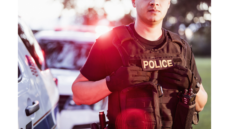 Hispanic police officer wearing bulletproof vest