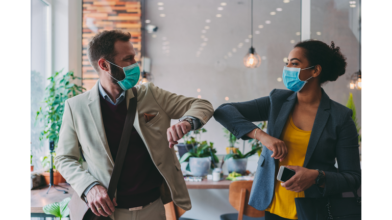 Business people greeting during COVID-19 pandemic, elbow bump