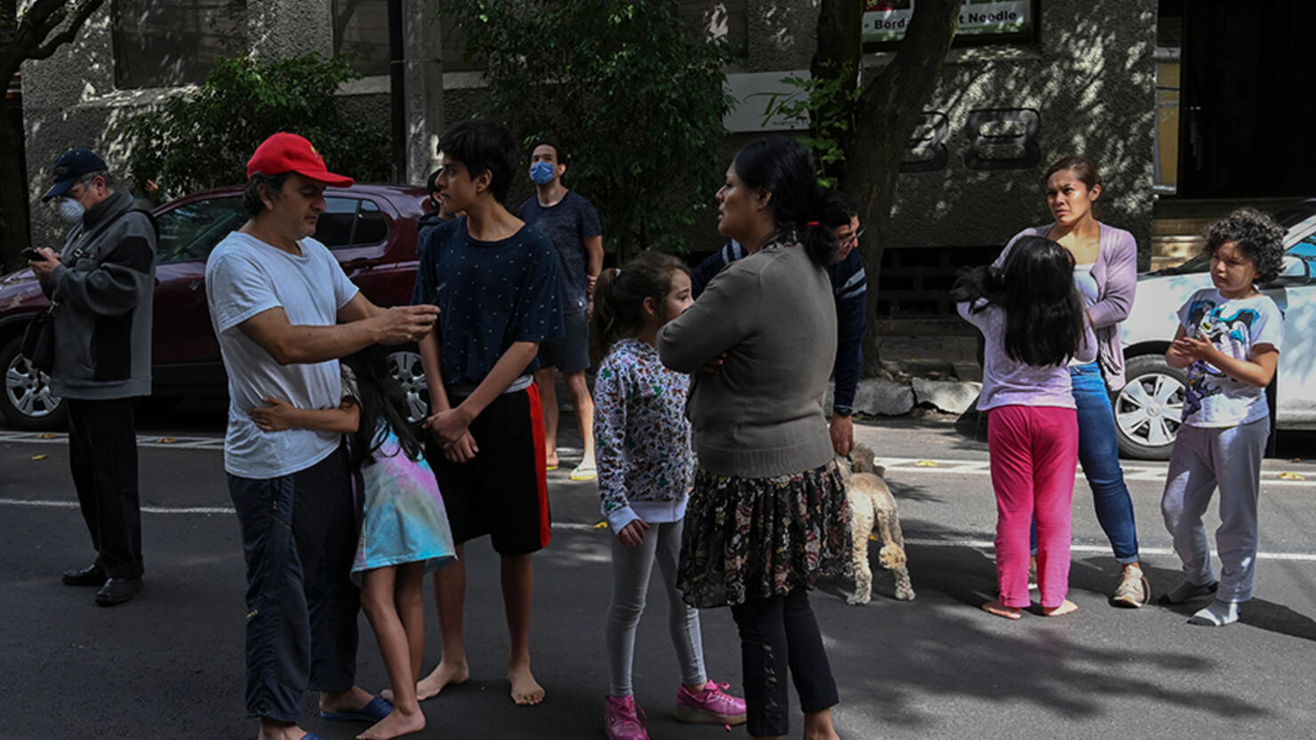 People are seen on a street during a quake in Mexico City, on June 23, 2020. - A 7.1 magnitude quake was registered Tuesday in the south of Mexico, according to the Mexican National Seismological Service. (Photo by RODRIGO ARANGUA / AFP) (Photo by RODRIGO