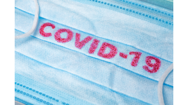 Blue Medical Disposable Face Mask with covid-19 printed on it. Covid-19 - Wuhan Novel Coronavirus pneumonia gets official name from WHO: COVID-19. Disposable breath filter face mask with earloop