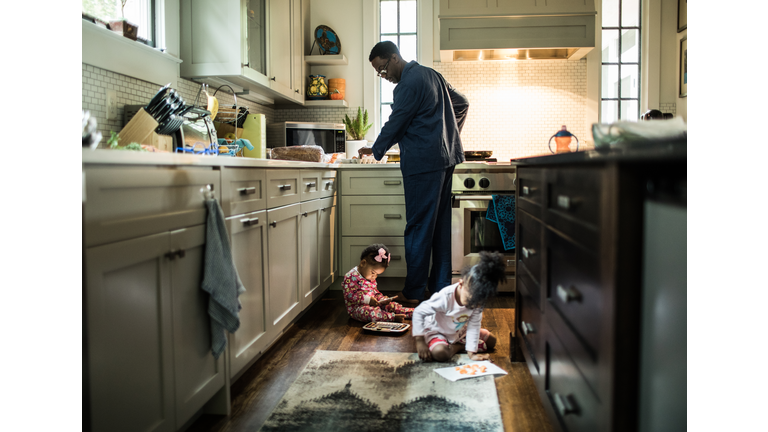 Father cooking breakfast for daughters in kitchen