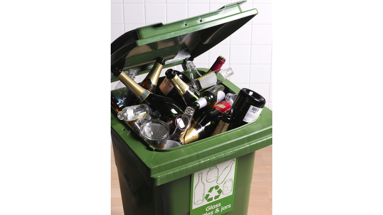 Open recycling bin with full of glass bottles, close-up