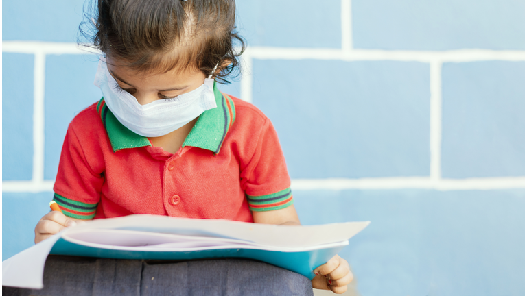 Student Wearing Mask Reading Book At School