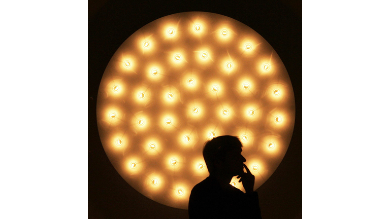 A visitor stands in front of a lamp by t