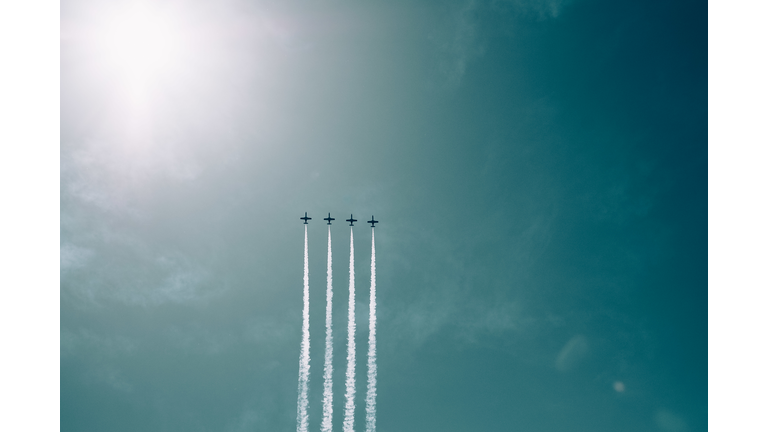Low Angle View Of Airplanes Flying Against Blue Sky
