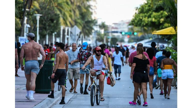 People walk on Ocean Drive in Miami Beach, Florida on June 26, 2020