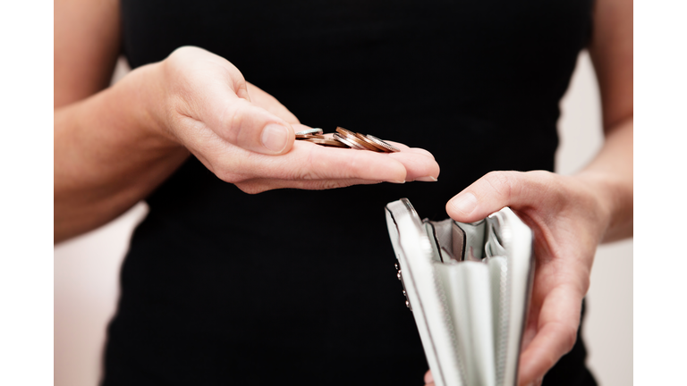 Woman with coins in hand with purse