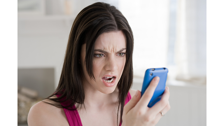 Angry woman looking at cellphone