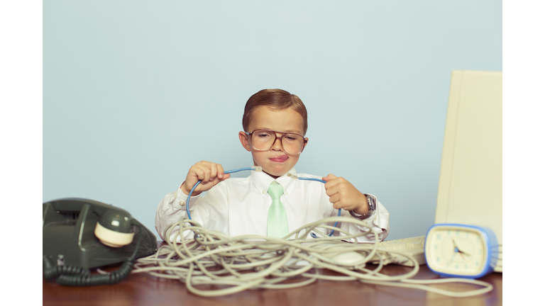 Young Boy IT Professional Smiles at Computer with Wire