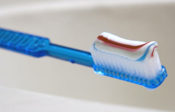 A toothbrush with toothpaste sits on a s