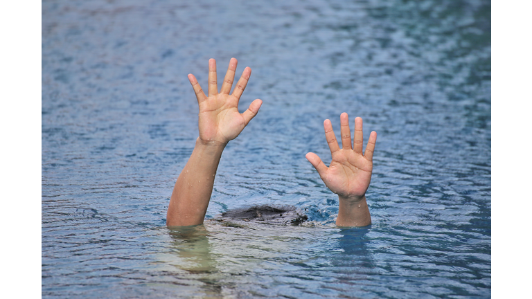 Man drowning in out door swimming pool while swimming alone, show two hands and asking for help