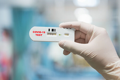 Doctor hand holding positive Coronavirus or Covid-19 rapid test